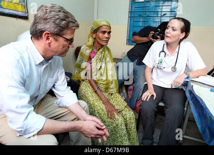 Bundesaußenminister Guido Westerwelle (FDP) und die Ärztin Louise Kühne sitzen mit einer unterernährten Patientin am Samstag (23.06.2012) in einer Arztpraxis der Hilfsorganisation 'Ärzte für die 3. Welt' im Slum von Korail in Dhaka (Bangladesch). Hier versorgen deutsche Ärzte ehrenamtlich die Bedürftigen. Foto: Jan Woitas dpa  +++(c) dpa - Bildfunk+++ Stock Photo