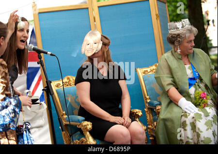 A woman dressed as Queen Elizabeth (R) and a woman wearing a mask of Camilla, Duchess of Cornwall (M), take part in the 'Queens Casting' during the Celle castle festival at the Castle Park in Celle, Germany, 07 July 2012. The 'Queens Casting' honors the best costume and knowledge about the British royal family. This summer, British forces will be leaving the garrison town after bei Stock Photo