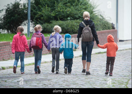 (file) A dpa file picture dated 09 August 2011 shows a woman leading children by the hand in the old city of Stralsund, Germany. On 13 July, the German Federal Court (BGH) in Karlsruhe decides whether a nanny is allowed to babysit children in her private living space or if other residents can forbid her from doing so. Photo: Stefan Sauer Stock Photo