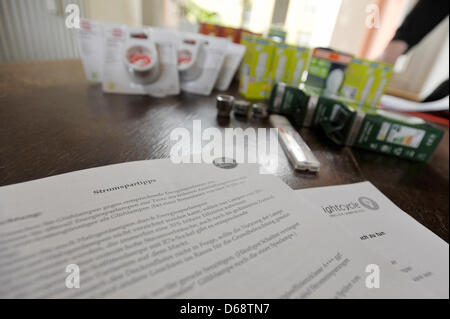 Energy saving devices and tips for saving energy lie on a table in a flat in Berlin, Germany, 18 July 2012. Campaign Electricity Saving Check wants to lower energy consumption in low-income households to ease the burden of costs. Long-term unemployed also get the chance to attempt reentering the job market via their work as an electricity-saving helper. Photo: Markus Heine Stock Photo