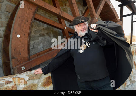The black miller aka Dieter Klimek stands in front of the mill wheel at the Krabat adventure farm in the Hoyerswerda district Schwarzkollm, Germany, 28 March 2012.  Krabat is a German fantasy novel by Otfried Preussler first published in 1971. It is the basis of different films, such as The Sorcerer's Apprentice and the 2008 live-action film Krabat. Photo: Britta Pedersen Stock Photo
