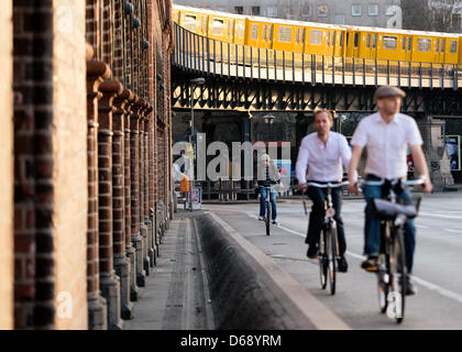 (FILE) An archive photo dated 24 March 2012 shows people cycling over the Oberbaum Bridge at sunset in Berlin, Germany. Photo: Britta Pedersen Stock Photo