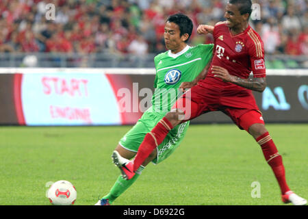 Wolfsburg's Makoto Hasebe (L) vies for the ball with Bayern Munich's Luiz Gustavo during the test match of the German Bundesliga soccer clubs VfL Wolfsburg vs FC Bayern Munich in Guangzhou, China, 26 July 2012. Photo: Roland Hermstein Stock Photo