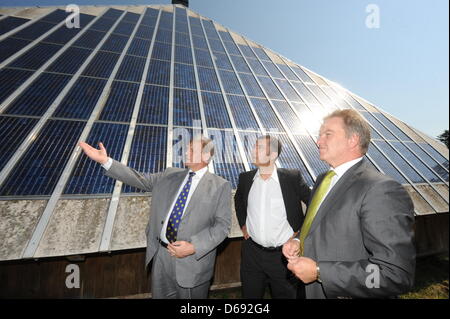 Director of the Fraunhofer Institute for Solar Energy Systems ISE in Freiburg, Eike Weber (L-R), co-chairman of the Green Party Cem Oezdemir and Minister of the Environment of Baden Wuerttemberg Franz Untersteller (Green Party) stand in front of solar panels on the roof of the inn Rappendecker Huette in Oberried, Germany, 27 July 2012. Rappendecker Huette was the first solar-poweer Stock Photo