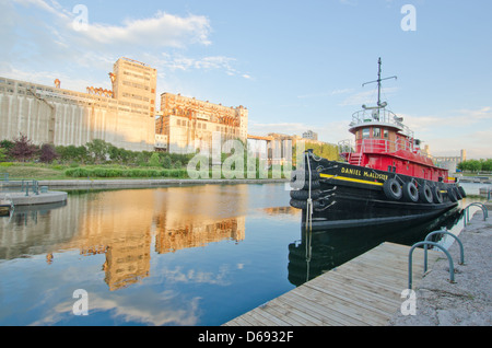 Old structure with silos and a tug boat in Montreal old port Stock Photo