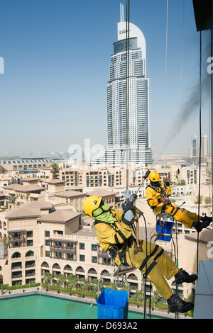 Window cleaners abseiling down high-rise apartment building in Dubai United Arab Emirates Stock Photo