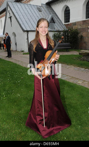 12-year-old Lara Boschkor poses for the camera with a violine of Carlo Antonio Testore built in 1740 in Milan during the 12. Summer Concert held at church Saint Severin in Keitum on the island Sylt, Germany, 27 July 2012. Photo: Jens Kalaene Stock Photo