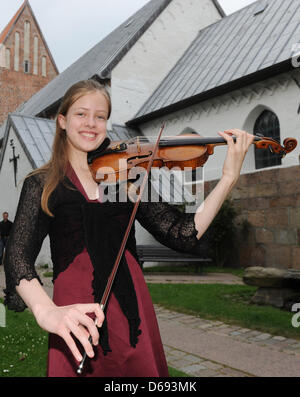 12-year-old Lara Boschkor poses for the camera with a violine of Carlo Antonio Testore built in 1740 in Milan during the 12. Summer Concert held at church Saint Severin in Keitum on the island Sylt, Germany, 27 July 2012. Photo: Jens Kalaene Stock Photo