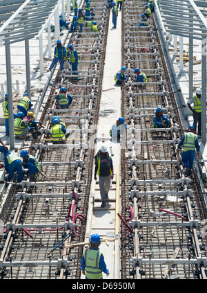 Construction workers laying railway tracks for  new Al Sufouh Tramway in Dubai United Arab Emirates Stock Photo