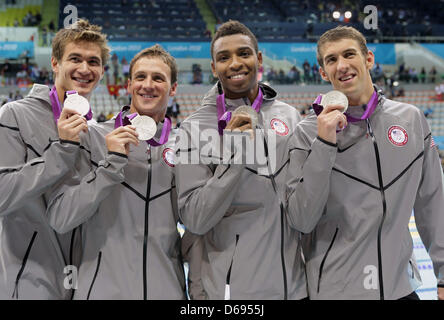 US team members Nathan Adrian (L-R), Ryan Lochte, Cullen Jones and Michael Phelps show their silver medals after the men's 4x100m Freestyle relay during the Swimming competition held at the Aquatics Center during the London 2012 Olympic Games in London, England, 29 July 2012. Photo: Michael Kappeler dpa  +++(c) dpa - Bildfunk+++ Stock Photo