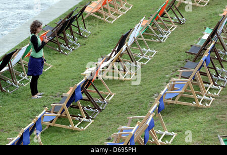 A waitress walks through rows of empty deck chairs at 22 degrees centigrade in a beach bar at the Spree in Berlin, Germany, 30 July 2012. Meteorologists predict hotter temperatures around 30 degrees for the nest few days. Photo: WOLFGANG KUMM