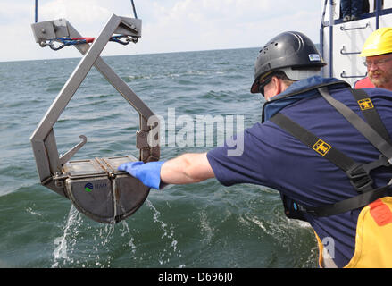 Technicians Holger Geldner (L) and Kai Brosda from the Istitute of Applied Ecology (IfAOE) examine the recovery of the sea floor around the pipe trench with a remotely operated underwater vehicle from the private research vessel 'Professor Albrecht Penck' on the Baltic Sea near Lubmin, Germany, 31 July 2012. The institute is working on behalf of Nord Stream AG - builder and operato Stock Photo