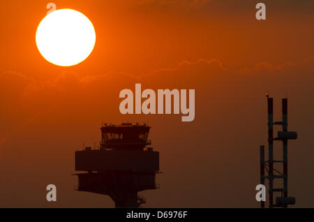 FILE - An archive picture dated 26 June 2012 shows the setting sun over the tower of the future Berlin-Brandenburg Airport (BER) in Schoenefeld, Germany. German Minister of Transport Ramsauer (CSU) proposed not to stick to the airport's new opening date at all costs. Photo: Soeren Stache Stock Photo