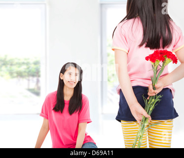 Little girl giving carnation flowers to mother on mother's day Stock Photo