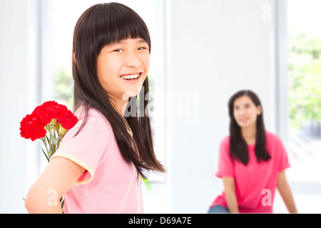 Little girl giving carnation flowers to mother on mother's day Stock Photo