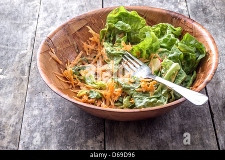 Green salad with grated carrots on table,half empty Stock Photo