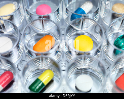A variety of drugs sitting in a multi well sample tray Illustrating drug clinical trial Stock Photo