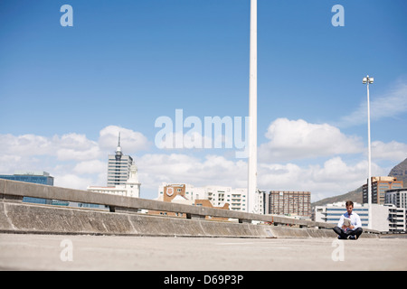 Businessman sitting on city street Stock Photo