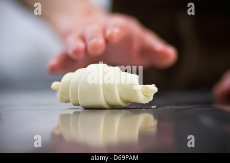 Close up of baker rolling dough Stock Photo