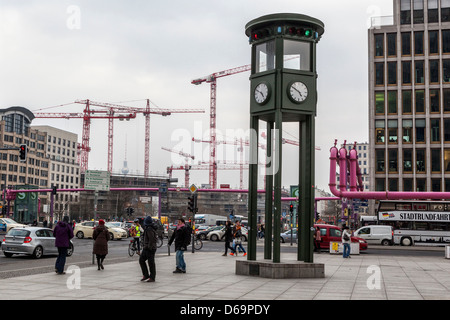 Building works, cranes, clock and pink pipes that drain surface water from construction sites in Berlin Stock Photo