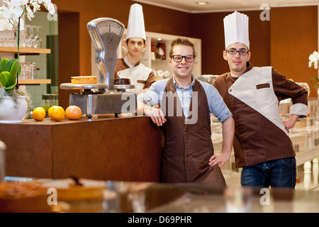 Cashier and bakers smiling in bakery Stock Photo