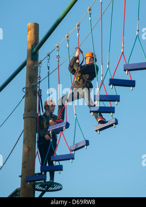 Teenage boys climbing on obstacle course Stock Photo