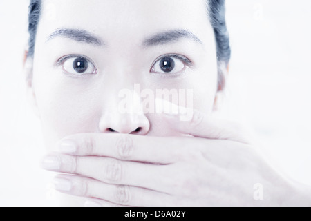 Close up of woman covering her mouth Stock Photo