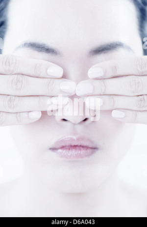 Close up of woman covering her eyes Stock Photo