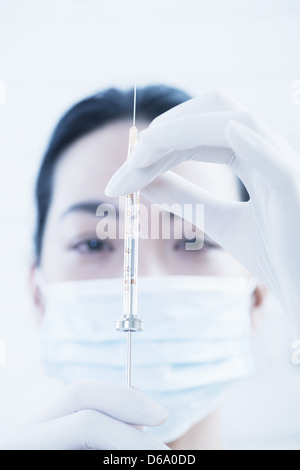 Doctor examining syringe Stock Photo