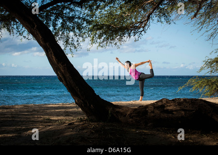 Woman practicing yoga on beach Stock Photo