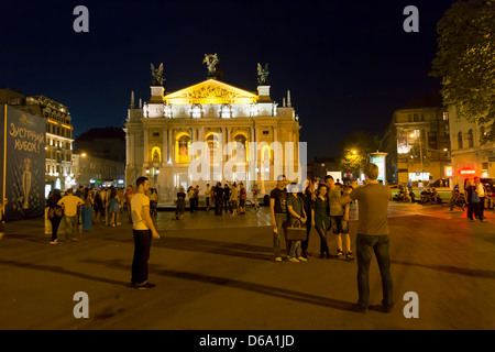 Lviv, Ukraine, young people have a souvenir photo at the fountain in front of the Opera Stock Photo