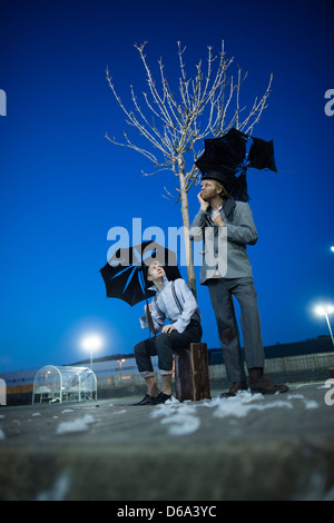 2 actors performing as Vladimir & Estragon in Samuel Beckett's classic play 'Waiting for Godot' in a deserted carpark at night Stock Photo