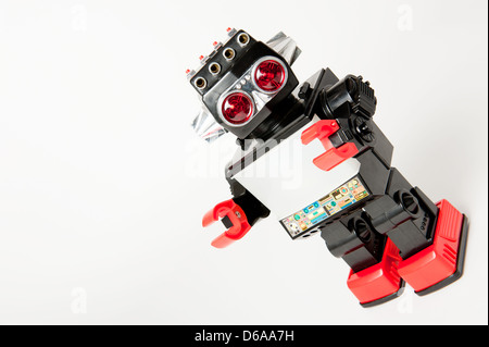 Angled view of a 1980's plastic toy robot against a white background. Stock Photo