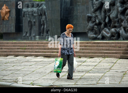 Lviv, Ukraine, woman with Einkaufstueten front of the monument from the Soviet era Stock Photo