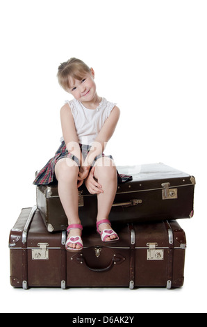 The little girl on old suitcases Stock Photo