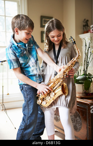 Children playing with saxophone Stock Photo