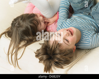 Children playing on sofa together Stock Photo