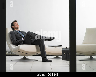 Businessman sitting in office lobby Stock Photo
