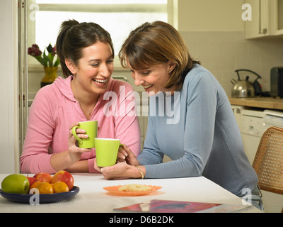 Women having coffee together in kitchen Stock Photo