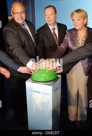 German Federal Environment Minister Peter Altmaier (L-R), CEO of RWE Peter Terium and Premiere of North Rhine-Westphalia Hannelore Kraft push a green button during an event for the start of operations of two new lignite fired power units at the existing RWE Neurath Power Station near Grevenbroich, Germany, 15 August 2012. The plant cost 2.7 billion euros and will reduce carbon diox Stock Photo