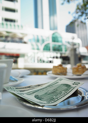 Money in tray on restaurant table Stock Photo