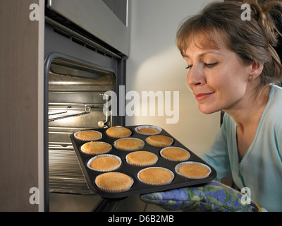Woman baking cupcakes in kitchen Stock Photo