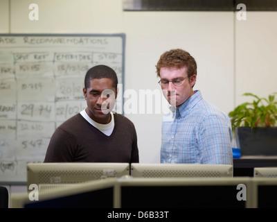Businessmen using computer at desk Stock Photo