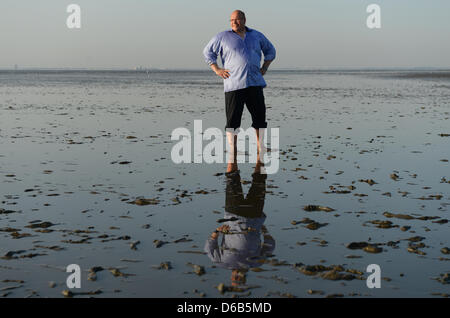 German Environment Minister Peter Altmaier stands in the mud flats during a tour through the North Sea during low tide near Friedrichskoog-Spitze, Germany, 19 August 2012. Minister Altmaier currently is on a energy, environment and summer tour through Schleswig-Holstein, Lower Saxony and North Rhine Westphalia.  Photo: Marcus Brandt Stock Photo