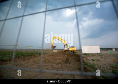 An excavator works on the premises of the future Nestle plant for coffee capsules in Schwerin, Germany, 20 August 2012. The Swiss food company has started the 220 million euro construction project. The plant is scheduled to be completed in 2014 offering 450 jobs. Photo: JENS BUETTNER Stock Photo