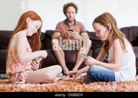 Girls playing cards on living room floor Stock Photo