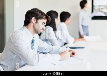 Businessman taking notes in meeting Stock Photo