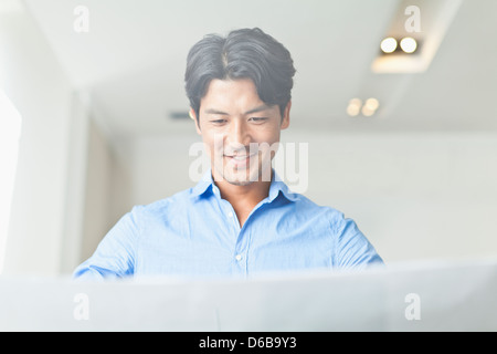 Businessman reading blueprints Stock Photo