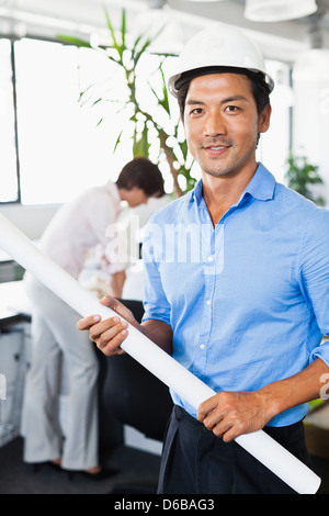 Businessman with blueprints in office Stock Photo