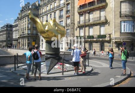 Tourists stand at the flame sculpture at the enntrance to the Pont de l'Alma tunnel, where Princess Diana died in a car accident on 31 August 1997, in Paris, France, 23 August 2012. The replica of the flame of the Statue of Liberty will be used as the location for the commemration of Diana. Photo: Benjamin Wehrmann Stock Photo